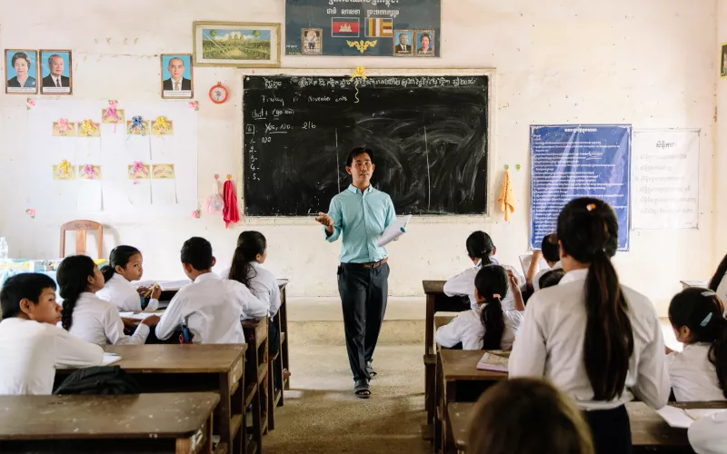 Teacher in Cambodia in front of a classroom