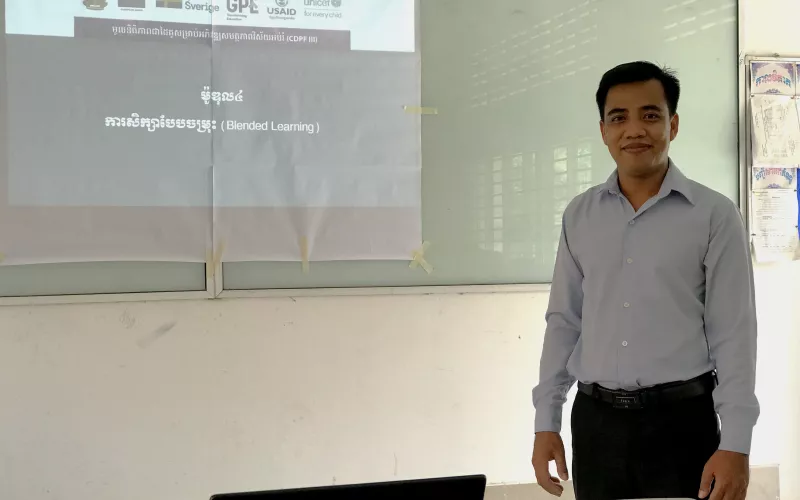 Portrait photo of male Cambodian teacher standing in a classroom
