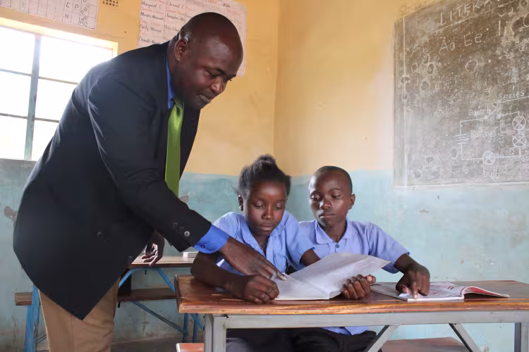 Teacher explaining to two learners during a Catch Up lesson