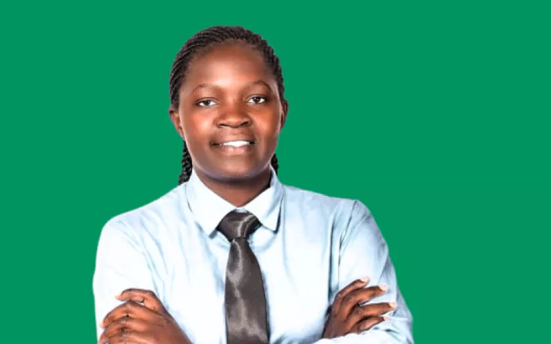 Image of teacher Victoria facing the camera with a green background behind her