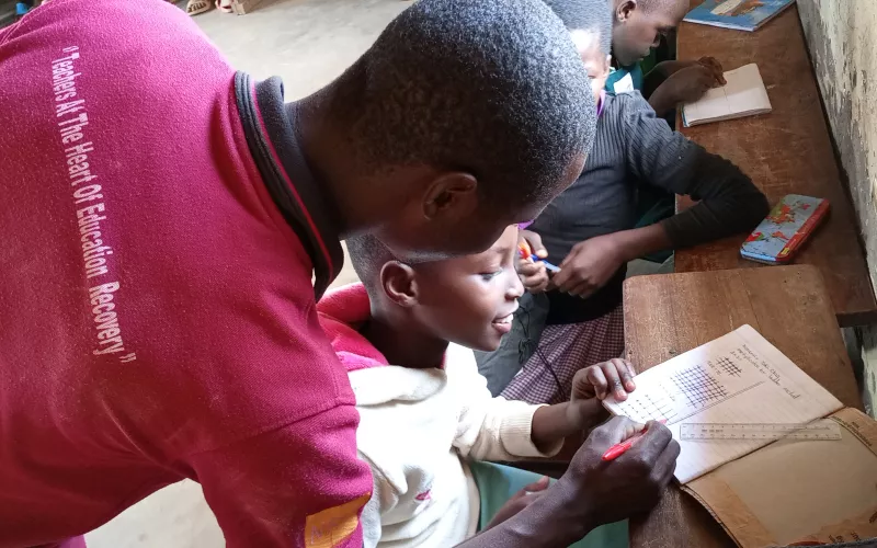 Shem, a Coordinating Centre Tutor is tutoring a young learner.