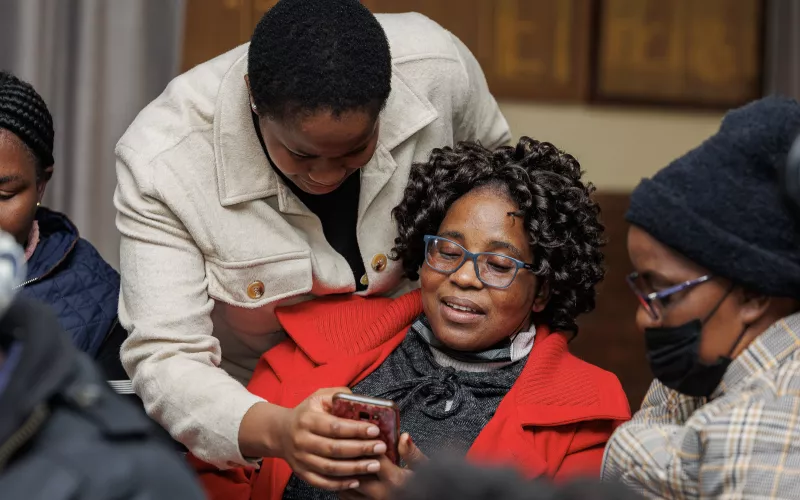 Two women looking together at a mobile phone. 