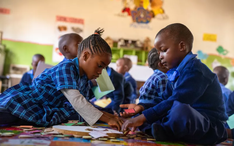 A boy and a girls playing together in the classroom.