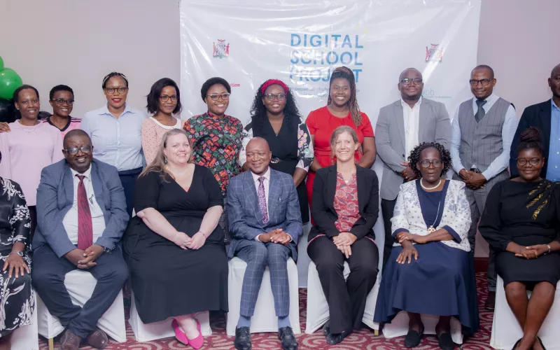 Group photo of participants and organisers of the Digital School Project event, standing and seated in front of a branded backdrop.