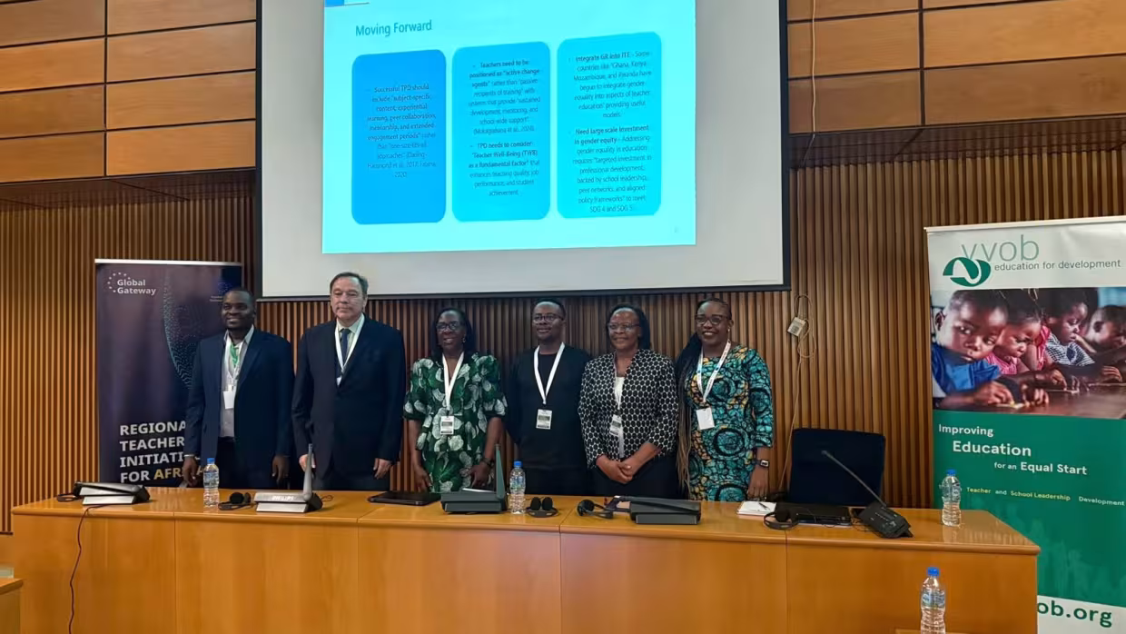 Six speakers stand in front of a presentation slide during a conference session, with VVOB and Global Gateway banners beside them.