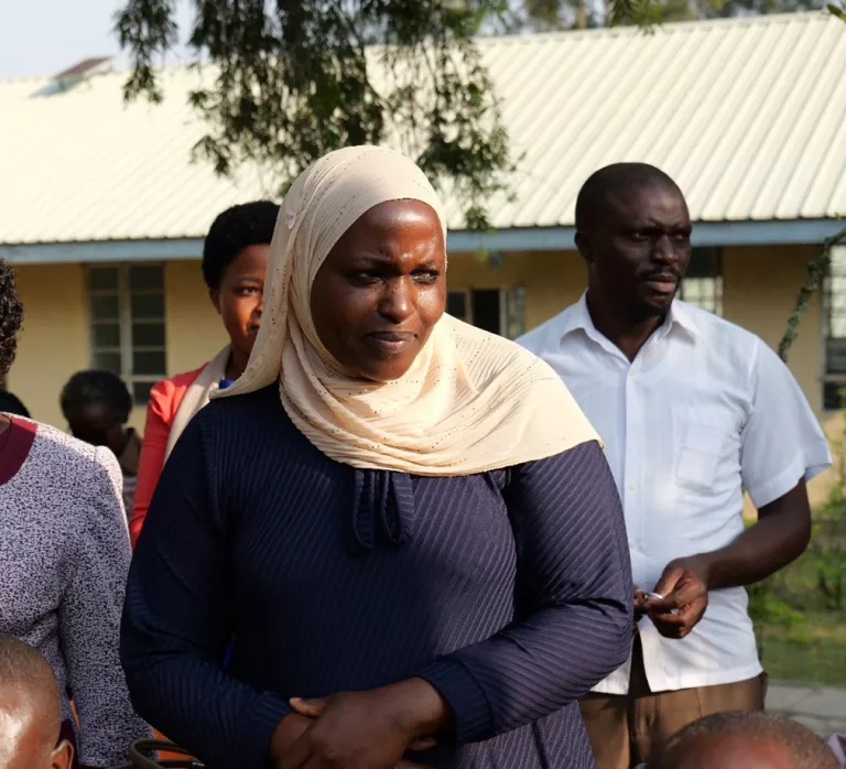 Woman standing outside wearing a white hijab.