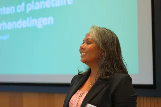 A VVOB staff member stands speaking in front of a large screen.