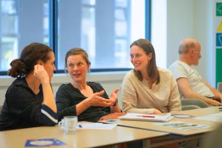 Three women seated, engaged in lively conversation.