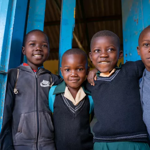 Four kids looking at the camera and smiling. 