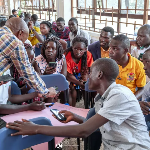 Facilitator interacts with university students during a group discussion activity
