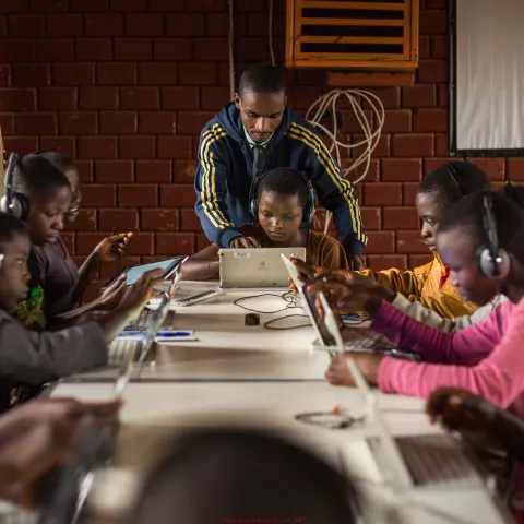 Children surfing on tablets, under the guidance of Alexis Nimubona, the facilitator in charge of the Ideas Box at the center. Credit: Kibuuka Mukisa Oscar / AFD