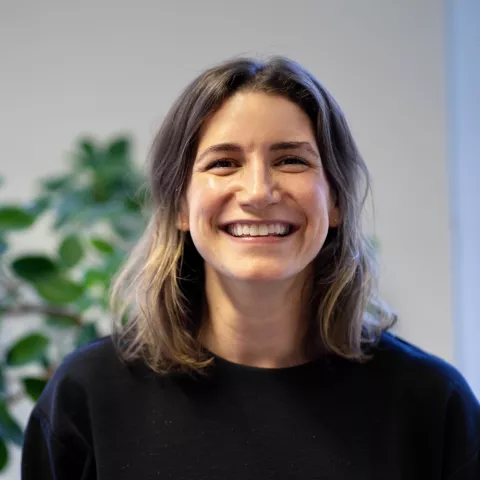 Nataša Ivačić smiling standing in front of a plant.