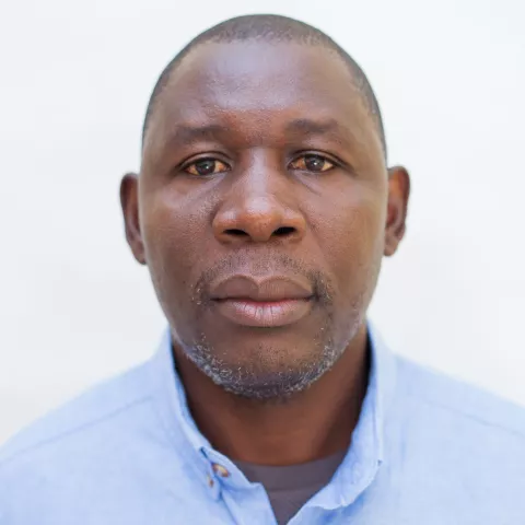 Davy is wearing a blue shirt. The background is plain white. 