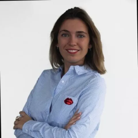 Ester is wearing a striped shirt. The background is plain white.