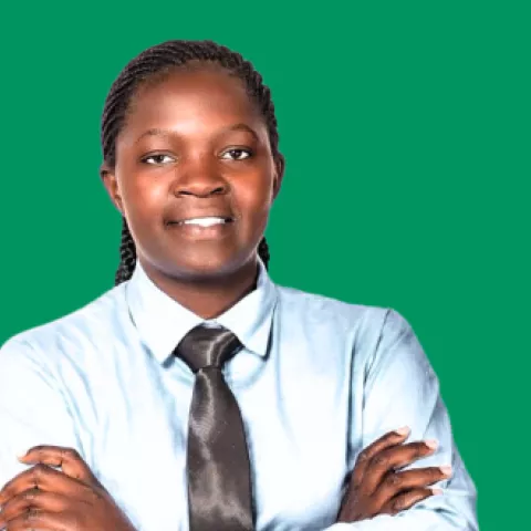 Image of teacher Victoria facing the camera with a green background behind her