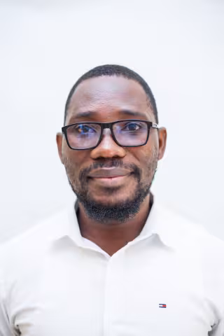 Morgan is wearing glasses and a white shirt. The background is plain white.