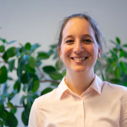 Sharon is smiling the camera, wearing a light-pink shirt.