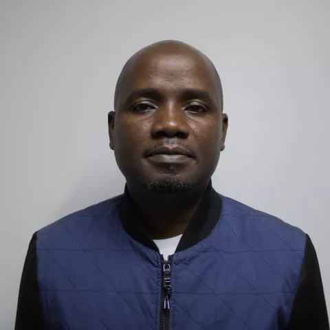 Sydney is wearing a blue jacket against a grey background.