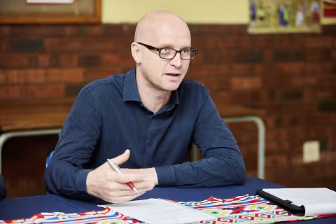 Jef Peeraer is sitting at a table, talking.