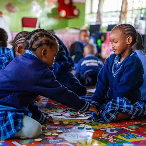 Two preschool children playing in a classroom in Zambia.