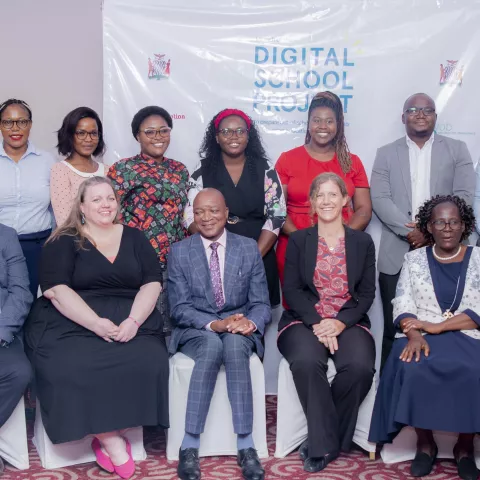 Group photo of participants and organisers of the Digital School Project event, standing and seated in front of a branded backdrop.