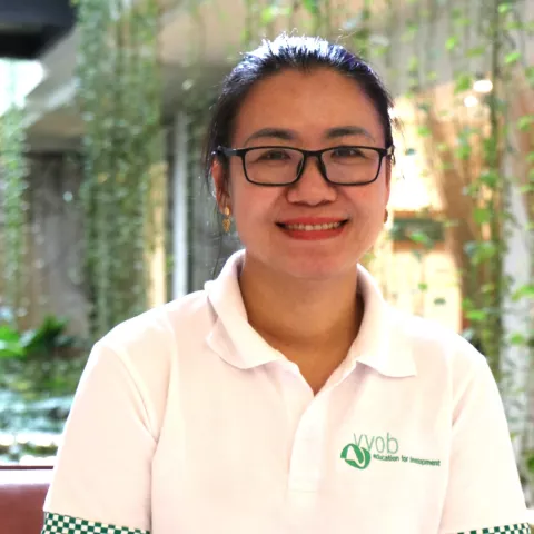 Khoy Rany is wearing a white shirt and glasses.